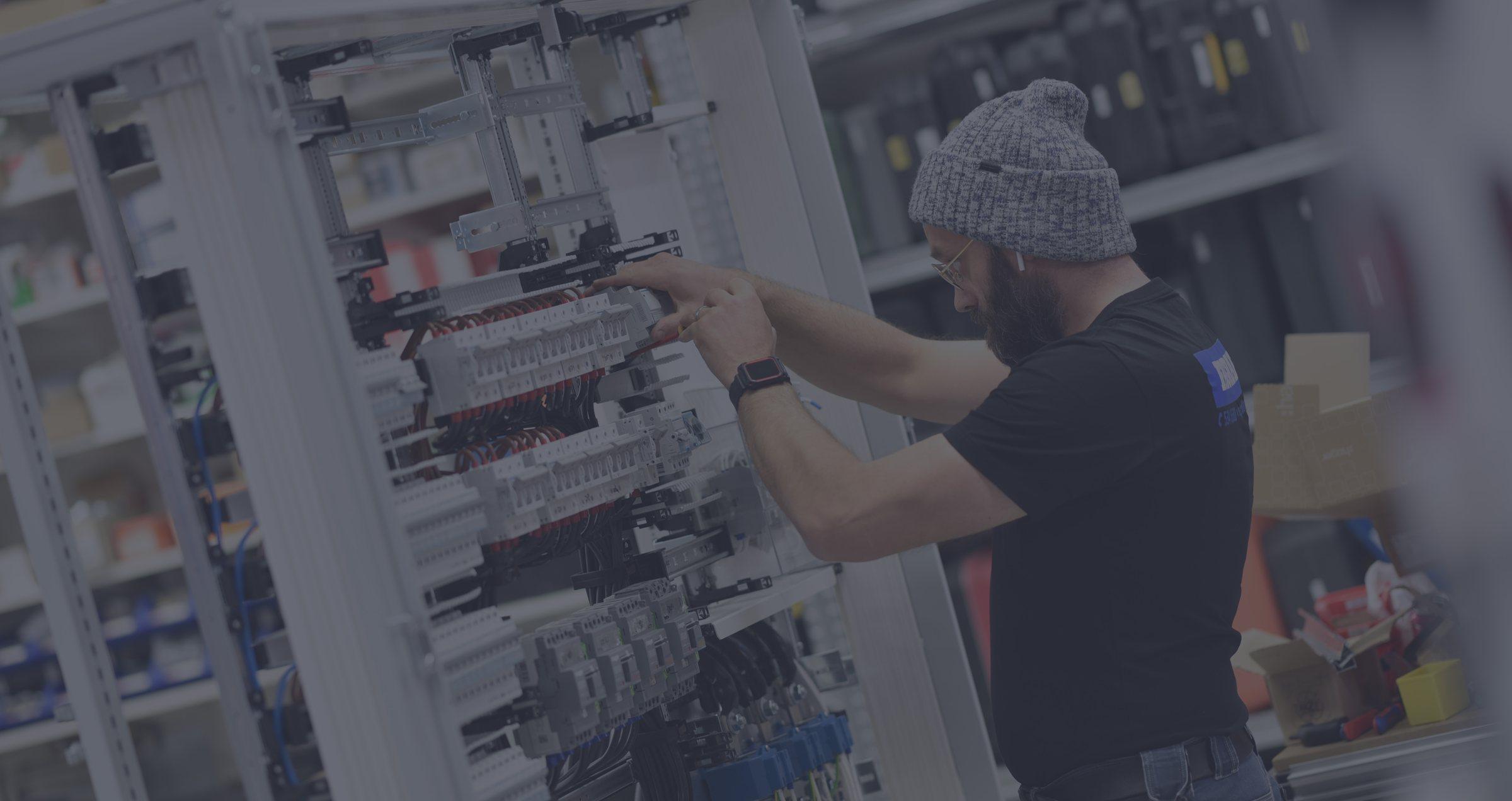 A Fagraf electrician wiring a circuit breaker cabinet