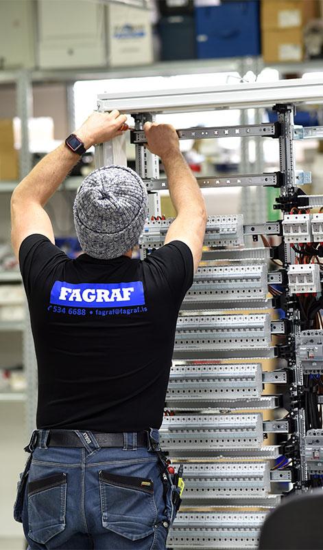 An electrician assembling a circuit breaker cabinet